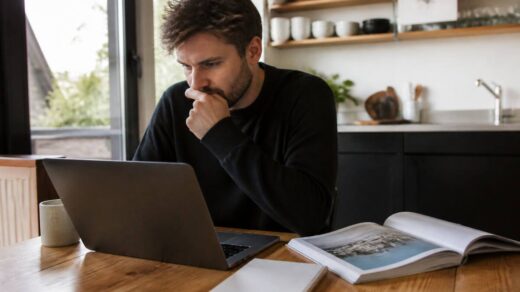 Iemand vergelijkt vakantieopties op een laptop aan de keukentafel